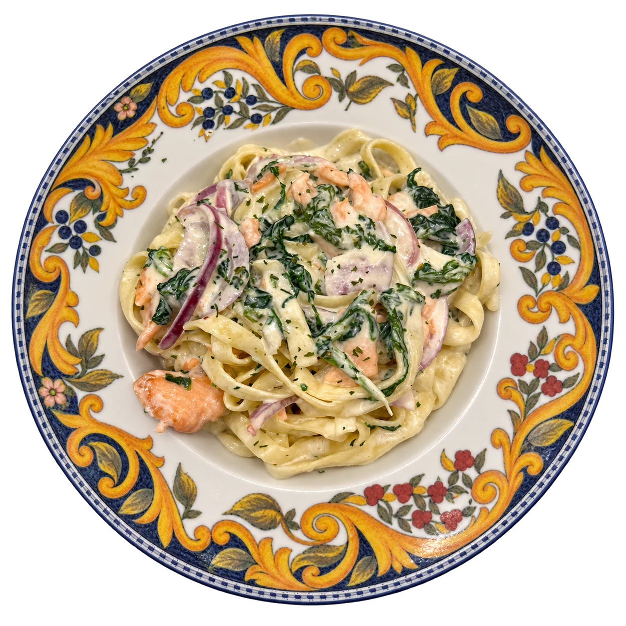 Pasta mit Lachs und Spinat in heller Sauce auf einem gemusterten Teller