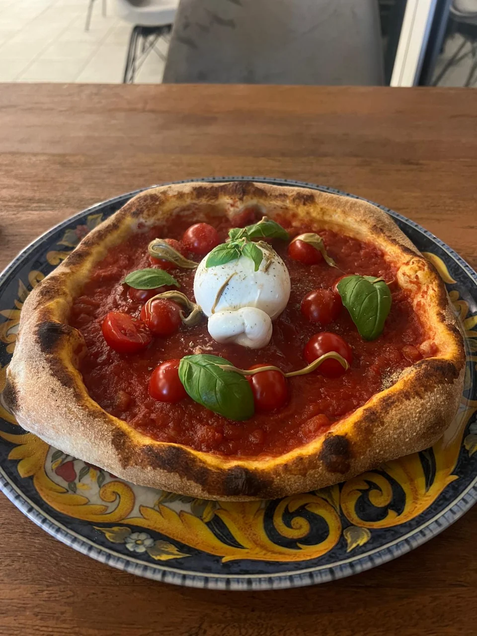 Pizza mit Käse, Tomaten und Basilikum auf einem Holztisch